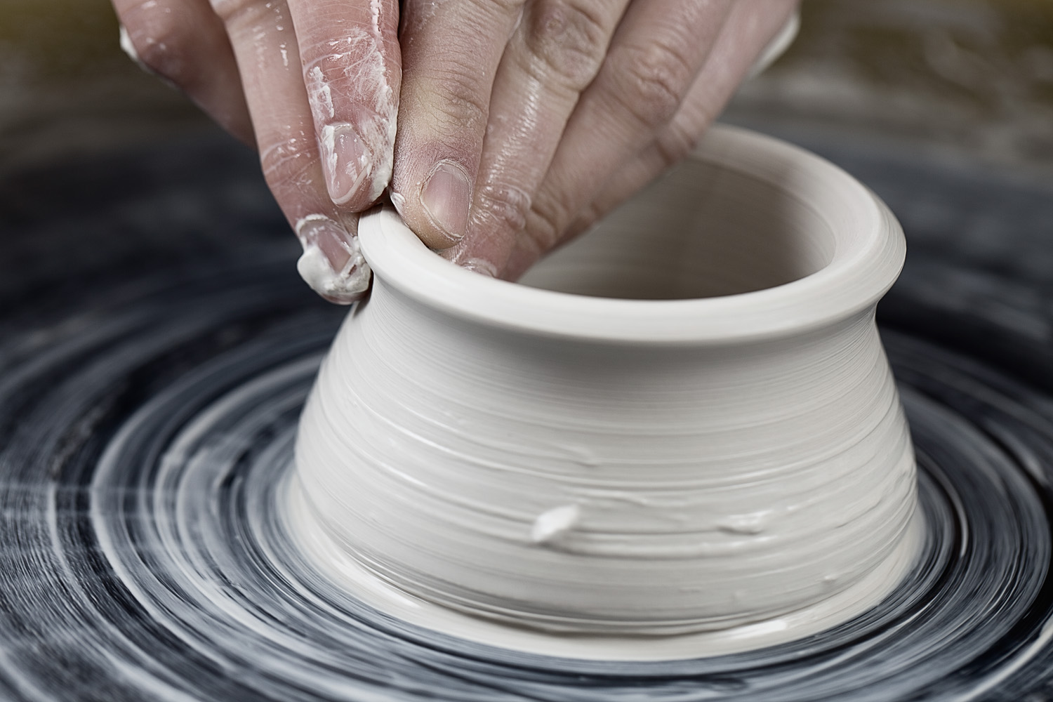 Lifestyle photography of forming clay pot on pottery wheel at ceramics studio  — Studio 3, Inc.