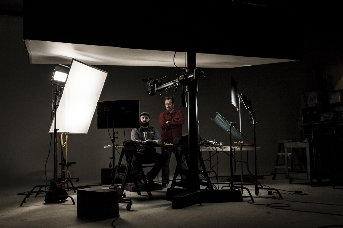 Director David King watching rushes with the talent on set of the Leatherman Wingman video shoot  — Studio 3, Inc.