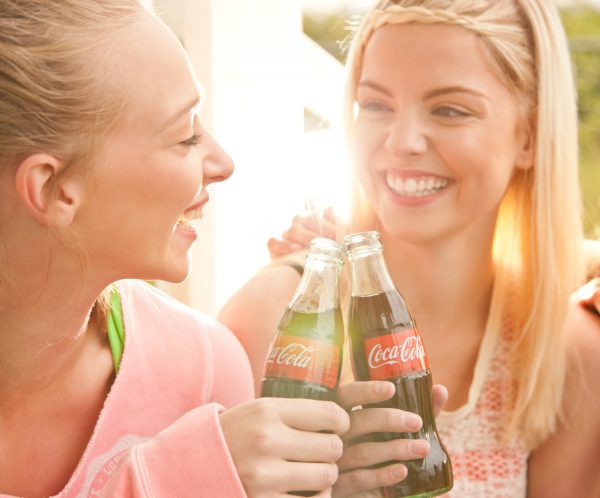 Two Smiling Women Drinking Coca-Cola