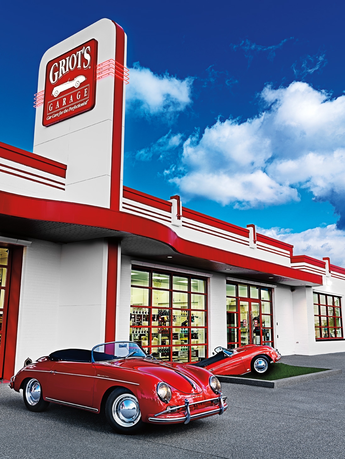 Outdoor shot of Griot's Garage Tacoma location with 2 red cars for Griot's Fall 2010 Catalog